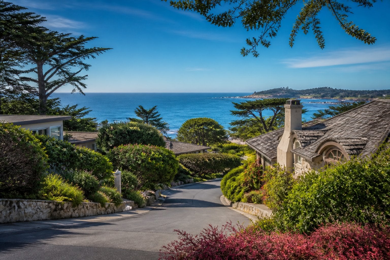 Coastal view of upscale homes surrounded by greenery overlooking the Pacific Ocean in Carmel-by-the-Sea, California.