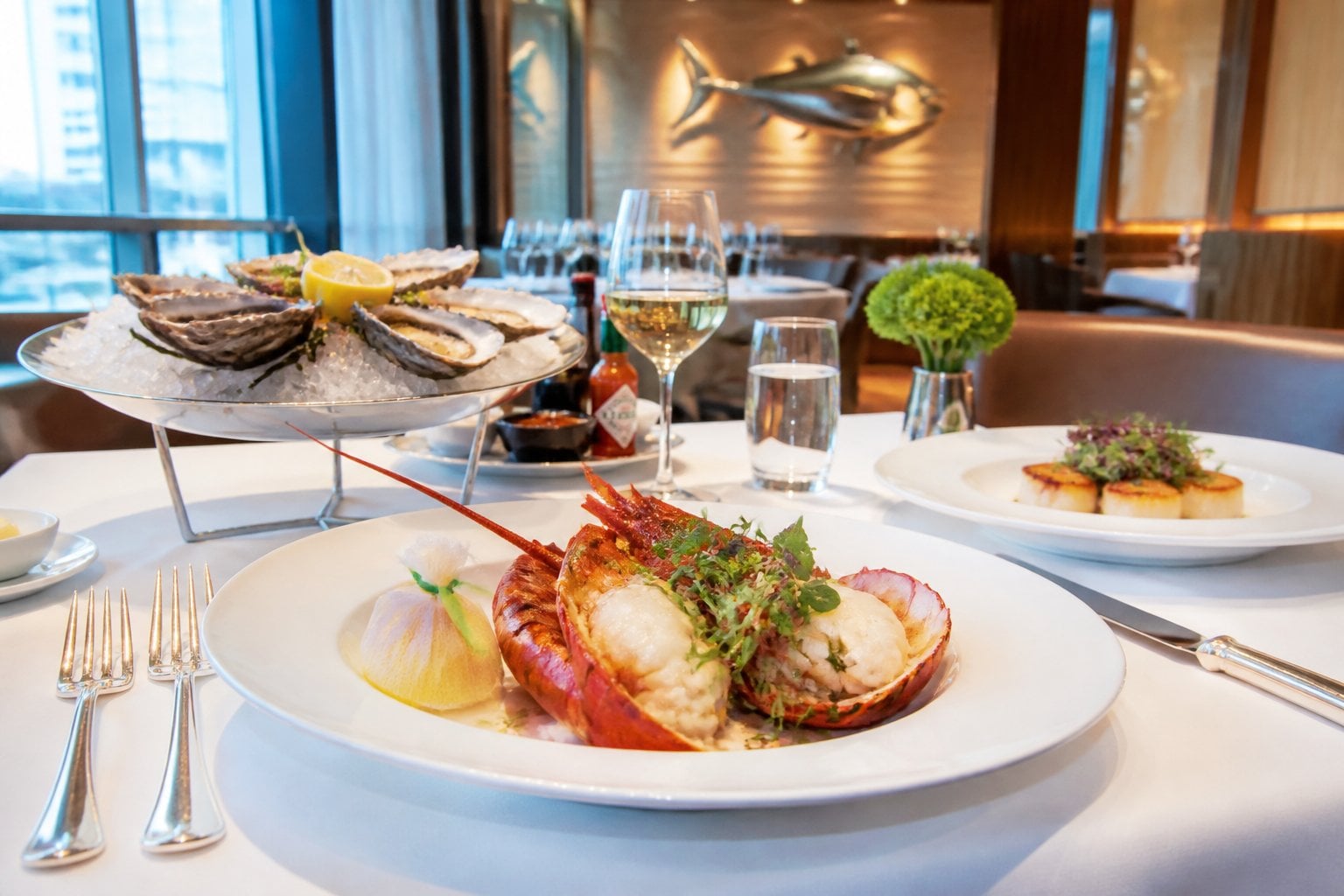 A fine dining table set with seafood dishes in an elegant restaurant interior.